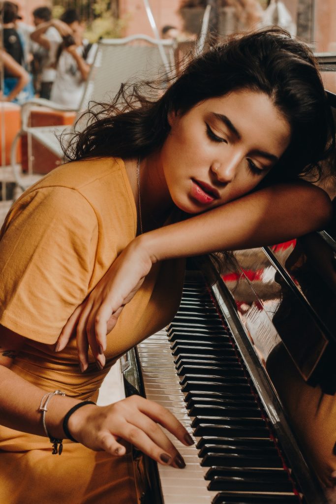 A muse is playing and listening to each piano note